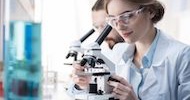 Kobieta patrząca przez mikroskop